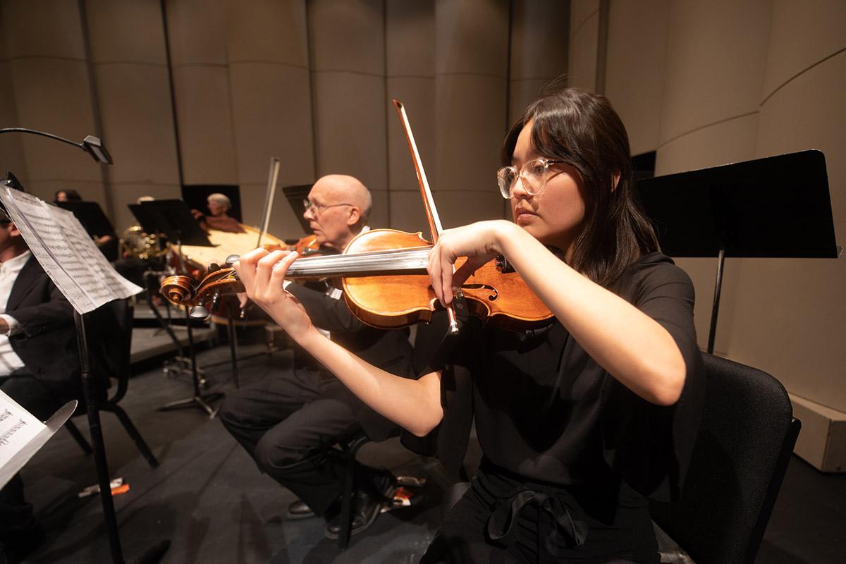 在排练期间，太阳集团娱乐场登陆网站交响乐团演奏小提琴部分.