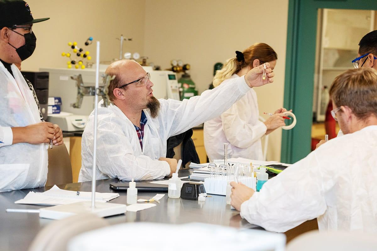 化学学生在实验室中与试管一起工作，并与老师合作
