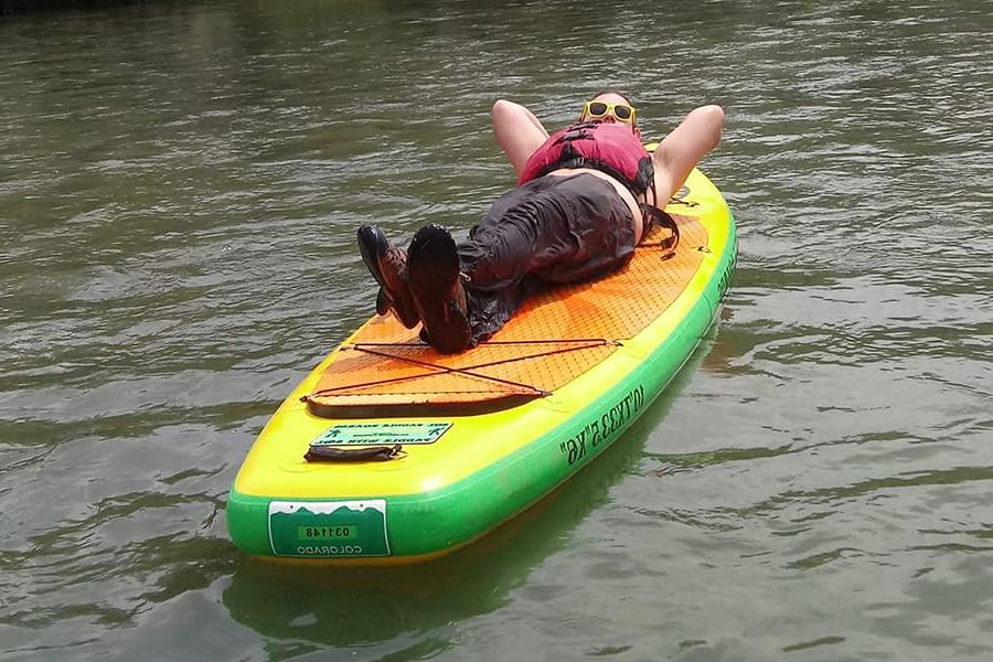 个人躺在桨板上漂浮在水面上